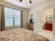Bedroom with bathroom access, king-size bed, and ceiling fan at 904 Charo Pkwy # 525, Davenport, FL 33897