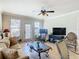 Spacious living room with comfortable seating, large TV, and access to balcony at 904 Charo Pkwy # 525, Davenport, FL 33897