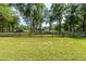 Landscaped yard with trees and a wooden fence at 12128 Sw 41St Pl, Ocala, FL 34481
