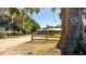 House exterior view with a long driveway and a wooden fence in front at 1402 Broken Oak Dr, Wildwood, FL 34785