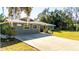 Front view of a gray house with a metal roof and a large yard at 1402 Broken Oak Dr, Wildwood, FL 34785