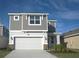 Two-story house with gray siding, white garage door, and landscaping at 2306 Amorie Dr, Kissimmee, FL 34746