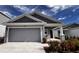 Gray one-story house with gray garage door, landscaping, and a light-colored walkway at 2343 Amorie Dr, Kissimmee, FL 34746