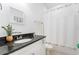 Clean bathroom with granite countertop, white cabinets, and a shower/tub combo at 476 Lake Shore Pkwy, Davenport, FL 33896