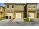 Tan two-story townhome with attached garage and mailbox at 476 Lake Shore Pkwy, Davenport, FL 33896