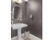 Stylish powder room with pedestal sink and dark gray walls at 100 S Eola Dr # 1411, Orlando, FL 32801