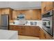 Modern kitchen with wood cabinets and stainless steel appliances at 100 S Eola Dr # 1411, Orlando, FL 32801
