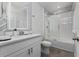 Modern bathroom with a glass shower, white cabinets, and a stylish chevron-patterned wall at 1251 Citrus Landing Blvd, Davenport, FL 33837