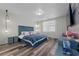 Spacious bedroom with a teal upholstered bed, wood-look floors, and modern nightstands at 1251 Citrus Landing Blvd, Davenport, FL 33837