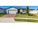 Single-story house with brick driveway, landscaped yard, and attached garage at 1251 Citrus Landing Blvd, Davenport, FL 33837