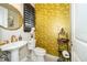 Elegant powder room featuring gold-scale wall tile and modern fixtures at 15939 Vetta Dr, Bella Collina, FL 34756
