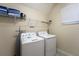 Convenient laundry room with washer, dryer, and shelving for storage at 2759 Bookmark Dr, Kissimmee, FL 34746