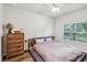Bright bedroom with a queen bed, dresser, and large window at 2920 Oak Park Way # Apt A, Orlando, FL 32822