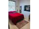 Bright bedroom with a red comforter, carpet, and artwork at 10642 Cloudview Dr, Orlando, FL 32825