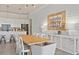 Modern dining room with wood table and white chairs, adjacent to kitchen at 1623 Green Orchard St, St Cloud, FL 34771