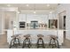 White kitchen island with four barstools, quartz countertops, and stainless steel appliances at 1623 Green Orchard St, St Cloud, FL 34771