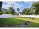 Landscaped backyard with grassy lawn, white fence, and mature trees at 1627 Illinois St, Orlando, FL 32803