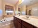 Bathroom with double vanity, garden tub, and large mirror at 1936 Marabou Dr, Davenport, FL 33896