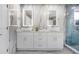 Double vanity bathroom with modern white cabinets and backlit mirrors at 2912 Sunset Lakes Blvd, Kissimmee, FL 34747