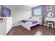 Charming bedroom with white platform bed, purple accents, and a dresser at 2912 Sunset Lakes Blvd, Kissimmee, FL 34747