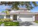 Two-story house with attached garage and manicured lawn at 2912 Sunset Lakes Blvd, Kissimmee, FL 34747