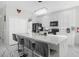 White kitchen with large island, stainless steel appliances, and marble countertops at 2912 Sunset Lakes Blvd, Kissimmee, FL 34747