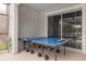 Covered patio with ping pong table and sliding glass doors leading to the backyard at 2912 Sunset Lakes Blvd, Kissimmee, FL 34747