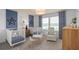 Bedroom with twin cribs, a sitting chair, and a view of a lake at 6018 Forest Perch Dr, St Cloud, FL 34771