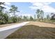 Concrete driveway leading to a house in a wooded area at 765 6Th Ave, Osteen, FL 32764