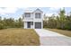 Two-story house with gray metal roof and gray garage door, sits on a grassy lot at 765 6Th Ave, Osteen, FL 32764