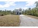 Two-story house with gray metal roof and gray garage door, sits on a grassy lot at 765 6Th Ave, Osteen, FL 32764