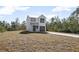 Two-story house with gray metal roof and gray garage door, sits on a grassy lot at 765 6Th Ave, Osteen, FL 32764