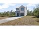 Two-story house with gray metal roof and gray garage door, sits on a grassy lot at 765 6Th Ave, Osteen, FL 32764