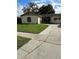 Tan house with brown shutters, well-maintained lawn, and a paved driveway at 2902 Calumet Dr, Orlando, FL 32810