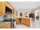 Open kitchen with granite countertops, stainless steel appliances, and wood cabinets at 300 Spring Run Cir, Longwood, FL 32779