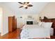 Main bedroom with hardwood floors, large bed, and wooden armoire at 300 Spring Run Cir, Longwood, FL 32779