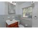 Clean bathroom with light grey tiled walls and wood vanity at 4272 Kendrick Rd, Orlando, FL 32804