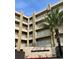 Tan three-story building with balconies and palm trees at 4501 S Atlantic Ave # 4090, New Smyrna Beach, FL 32169
