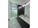 Bathroom with walk-in shower, dark vanity and marble tile at 547 Sanctuary Golf Pl, Apopka, FL 32712