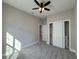 Bright bedroom with gray carpet, ceiling fan, and spacious closet at 547 Sanctuary Golf Pl, Apopka, FL 32712