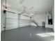 Two-car garage with epoxy flooring and staircase to upper level at 547 Sanctuary Golf Pl, Apopka, FL 32712