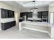 Modern kitchen with dark cabinetry, quartz countertops, and stainless steel appliances at 547 Sanctuary Golf Pl, Apopka, FL 32712