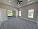 Main bedroom with gray carpet, sliding glass doors to patio, and ceiling fan at 547 Sanctuary Golf Pl, Apopka, FL 32712