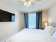 Relaxing bedroom with a comfortable bed, ceiling fan, and mounted TV at 7405 Excitement Dr, Kissimmee, FL 34747