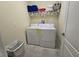 Well-equipped laundry room with washer, dryer, and storage shelves at 9037 Shadow Mountain St, Davenport, FL 33896