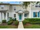 Two story townhome with teal door and landscaped walkway at 2844 Grasmere View Pkwy, Kissimmee, FL 34746