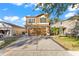 Two-story house with a tan exterior, attached garage, and landscaping at 15321 Beamleigh Rd, Winter Garden, FL 34787