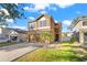 Two-story house with a tan exterior, attached garage, and landscaping at 15321 Beamleigh Rd, Winter Garden, FL 34787