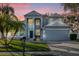 Two-story house with gray siding, a three-car garage, and a manicured lawn at 1813 Sugar Cove Ct, Ocoee, FL 34761