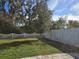 Private backyard with grassy area, white fence, and mature trees at 1884 Hickory Bluff Rd, Kissimmee, FL 34744